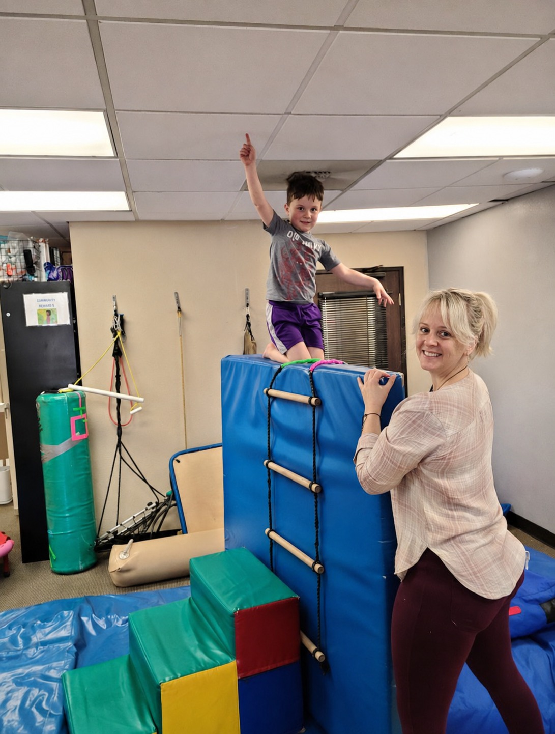A therapist supporting a child climbing during an active therapy session